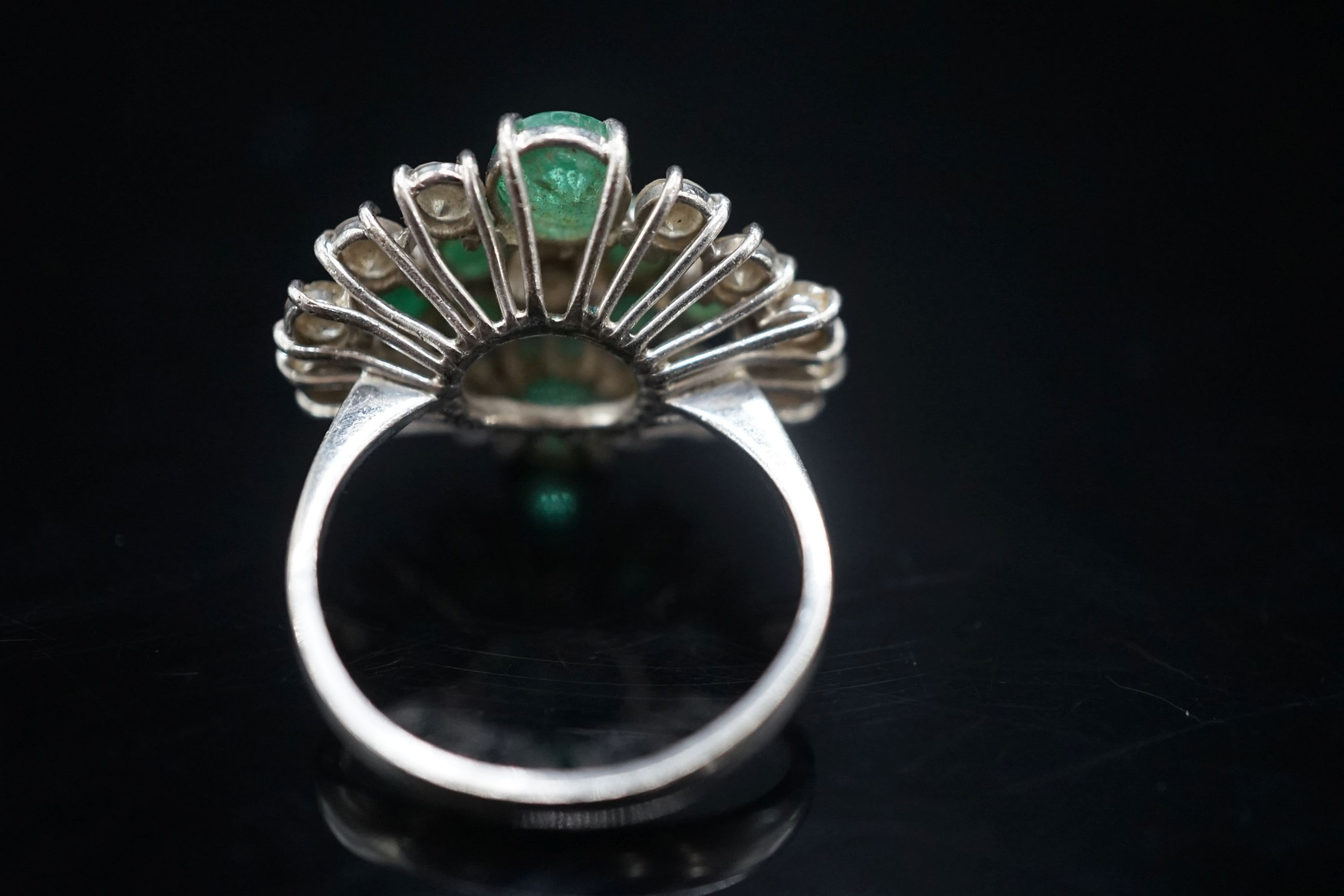 A 20th century 18ct white metal, emerald and diamond set cluster dress ring, size O/P, gross weight 7.3 grams.